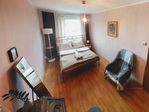 vistas a un dormitorio con cama y silla en Gdynia Baltic Apartment, en Gdynia