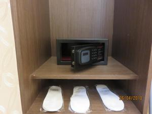a microwave oven sitting on a shelf next to a pair of shoes at Mao Hua Motel in Dajia