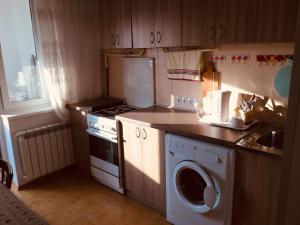 eine Küche mit Waschmaschine, Herd und Spüle in der Unterkunft Clean apartment on Lunacharskogo street in Tiraspol