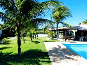 un complejo con piscina y palmeras en Excelente casa a 150 mts da Praia da Ferradura, en Búzios