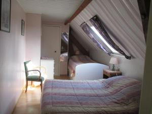 Schlafzimmer im Dachgeschoss mit einem Bett und einer Lampe in der Unterkunft 3 Rue Vicaire in Contalmaison