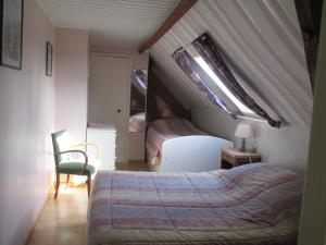 a attic bedroom with a bed and a lamp at 3 Rue Vicaire in Contalmaison