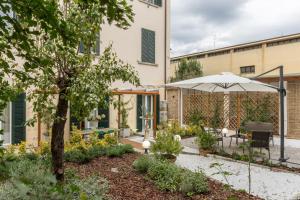 een tuin met een parasol en een tafel en stoelen bij Pilastri Majestic Garden in Florence
