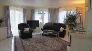 里茨勒恩的住宿－Alpentraum，客厅配有沙发、椅子和桌子