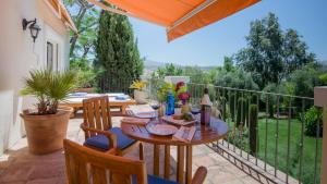 a patio with a table and chairs on a balcony at Hotel La Fuente de la Higuera in Ronda