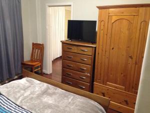 ein Schlafzimmer mit einer Kommode mit einem Fernseher drauf in der Unterkunft Affordable & comfortable Apartment on Langley Park in Perth