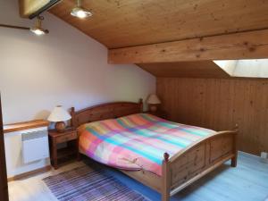 1 dormitorio con 1 cama y 2 mesitas de noche en Confortevole mansarda di montagna, en Poschiavo