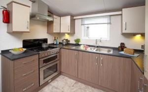a kitchen with wooden cabinets and a sink at Loch View in Taynuilt