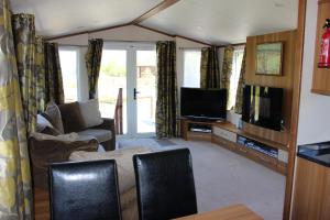 a living room with a couch and a flat screen tv at Loch View in Taynuilt