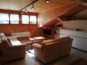 sala de estar con 2 sillas y mesa en Confortevole mansarda di montagna en Poschiavo