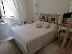 a bedroom with a white bed and a window at Il Vicolo di Ripa B&b in Ripatransone