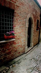 a brick building with a pot of flowers on a window at Il Vicolo di Ripa B&b in Ripatransone