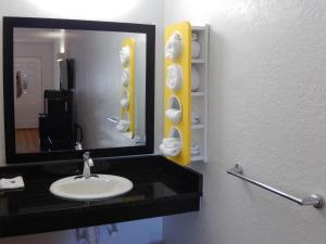 a bathroom with a mirror, sink, and toilet at Motel 6-Moultrie, GA in Moultrie
