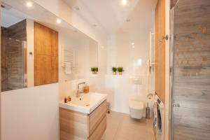 クラクフにあるBrowar Lubicz Residenceの洗面台とシャワー付きの白いバスルーム +51枚の写真