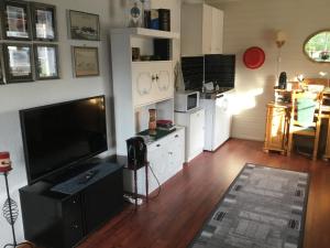 a living room with a large television and a kitchen at Kong Hans gt. 28 in Andenes