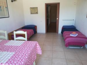 2 Betten in einem Zimmer mit rosa und lila Bettwäsche in der Unterkunft Behara in Marina di Ragusa