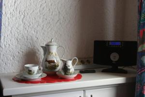 a tea pot and two cups on a counter at Ferienwohnung Bücker in Telgte