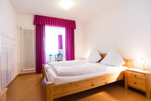 a bedroom with a large bed with purple curtains at Gasthaus Pension Löwen in Freiburg im Breisgau