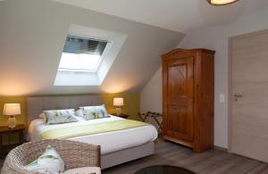 una camera con letto e lucernario di Maison d hotes Coeur de Village Alsace & spa a Rohrwiller