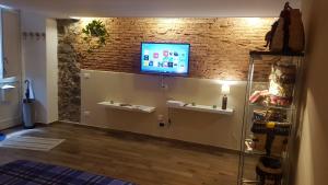 a living room with a tv on a brick wall at Holiday House da Carlo in Catania +78 photos