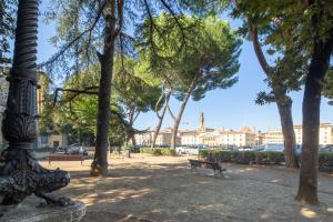 a park with a pole and benches and trees at Villoresi Mansion in Florence