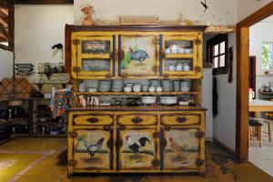 a wooden cabinet with birds painted on it in a kitchen at Pousada Vila Serrano in Lençóis