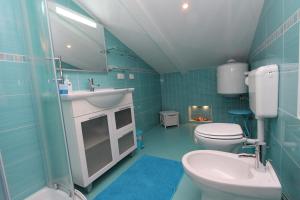 ein blaues Badezimmer mit Toilette und Waschbecken in der Unterkunft Apartments Daria in Rovinj