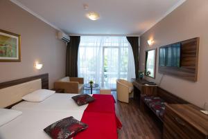 1 dormitorio con 1 cama y sala de estar en Regata Palace Hotel, en Sunny Beach