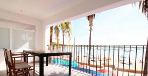 a balcony with a table and chairs and a view of the beach at Apartaments Es Port para largas estancias in Colònia de Sant Jordi