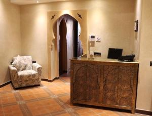 a lobby with a chair and a desk with a computer at DAR AMGHAR in Tafraout