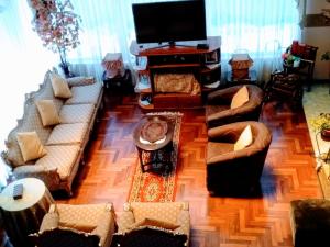 a living room with couches and a flat screen tv at Residencial Belle Maison in Cusco