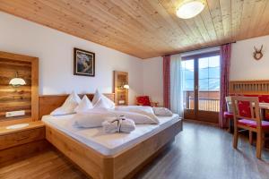 a bedroom with a bed and a large window at Hotel Kronhof in Moso