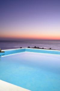 una piscina con vista sull'oceano sullo sfondo di Cavos Bay Hotel & Studios ad Armenistís
