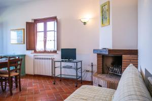 een woonkamer met een bank en een televisie bij Borgo Di Collelungo in Montaione