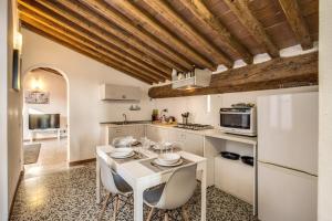 uma cozinha com uma mesa branca e cadeiras em AwesHomeItaly - Lungarno Bellavista Penthouse em Pisa