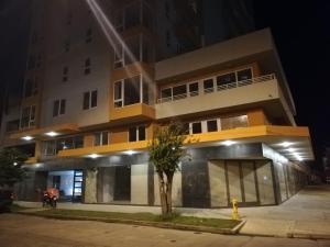 a building at night with a tree in front of it at Depto Estudio 1811 Edificio Centro Blanco con estacionamiento in Temuco