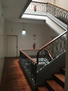 an empty stairway with a metal railing and a window at Chiado 2 Bedroom Elegant Apartment in Lisbon