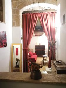 a living room with red curtains and a table at Appartamento La Loggia in Orvieto