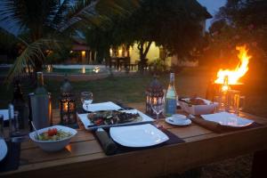 a wooden table with food on top of it with a fire at Wild Lotus Yala in Tissamaharama