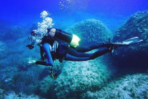 a person is swimming in the ocean at I Dammusi di Borgo Cala Creta in Lampedusa