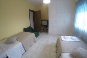 a bedroom with two beds and a chair and a television at Oasis of CalmnessΕ in Ardánion
