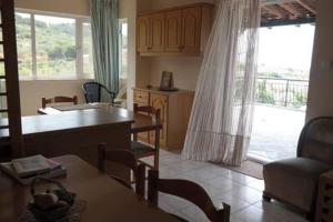a living room with a table and a kitchen with a view at Oasis of CalmnessΕ in Ardánion