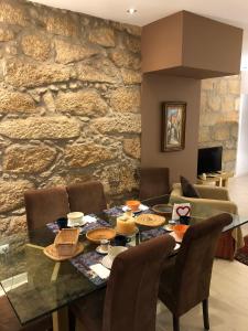 a dining room with a table and a stone wall at BS VILLAS RC PORTO in Porto