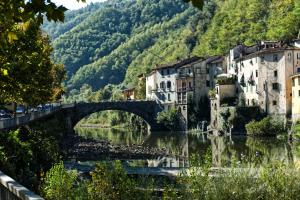 een brug over een rivier in een stad met gebouwen bij Casa Ella in Bagni di Lucca