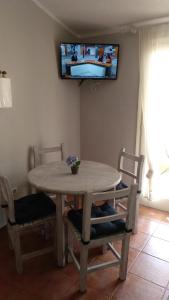 カラン・ボッシュにあるcova d es moro, apartamento 65のダイニングルーム(テーブル、椅子、壁掛けテレビ付)