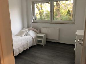 um pequeno quarto com uma cama e uma janela em Wohlfühlen In der Luft em Wesel