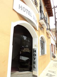 una señal de hotel en el lateral de un edificio en Hotel Silveira en Bambuí