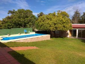 un patio con piscina y una casa en Casa de descanso Costa Azul, en La Floresta