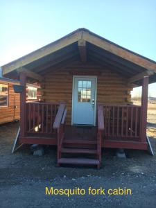 a log cabin with a porch and a door at Alaska Log Cabins on the Pond in Clear Creek Park