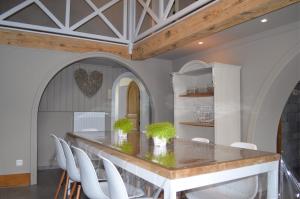 une salle à manger avec une table et des chaises blanches dans l'établissement la tourelle d’Achille leontine, à Rochefort